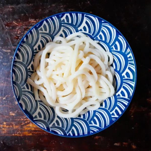 Rebus udon sesuai petunjuk di kemasan, angkat lalu rendam sebentar ke dalam air es. Agar kekenyalan udon tetap terjaga. Tuang kuah secukupnya kemudian susun topping daging, kemudian berikan taburan daun bawang dan irisan cabai. Siap dinikmati!