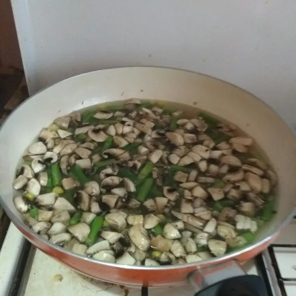 Masukkan jagung pipil lalu tambahkan jamur kancing.