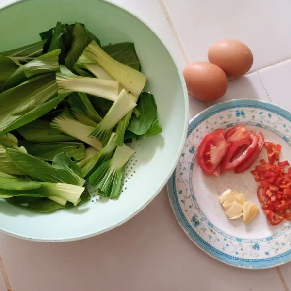 Siapkan bahan. Potong pakchoy 3 cm. Buang biji cabai iris tipis, geprek bawang putih dan potong tomat.