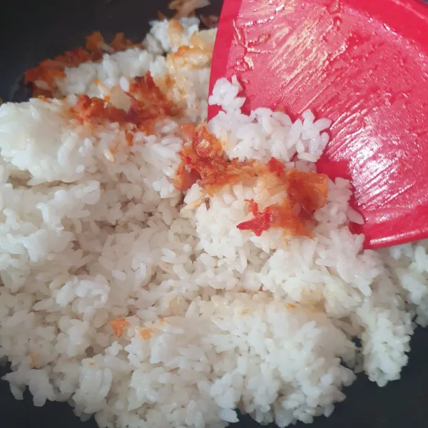 Masukkan nasi putih, aduk hingga tercampur dengan bumbu.