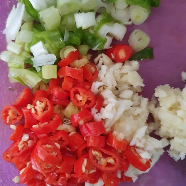 Iris-iris cabe dan daun bawang. Cincang bawang putih.