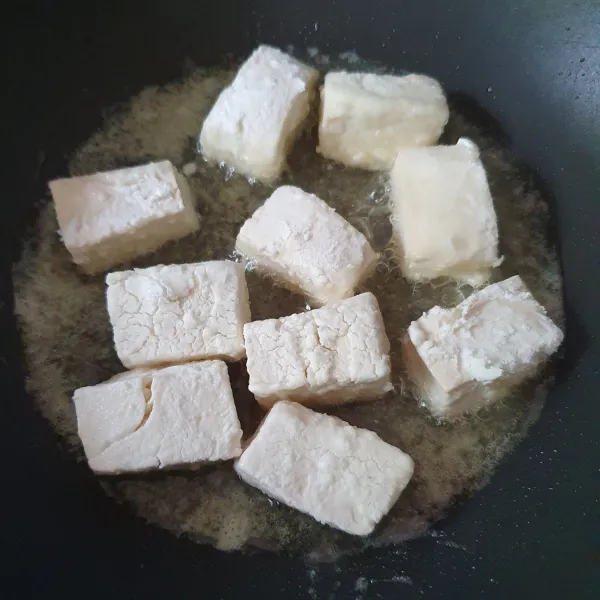 Campur maizena dan garam, masukkan potongan tahu. Goreng tahu hingga matang.