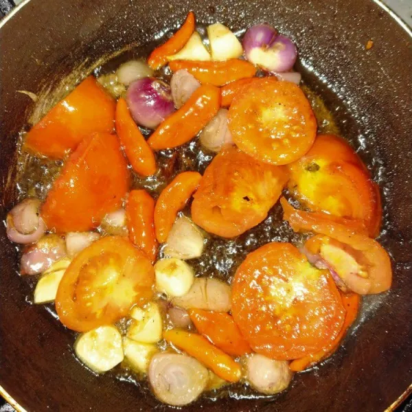 Panaskan minyak goreng, masukkan irisan tomat, bawang merah, bawang putih dan cabe.