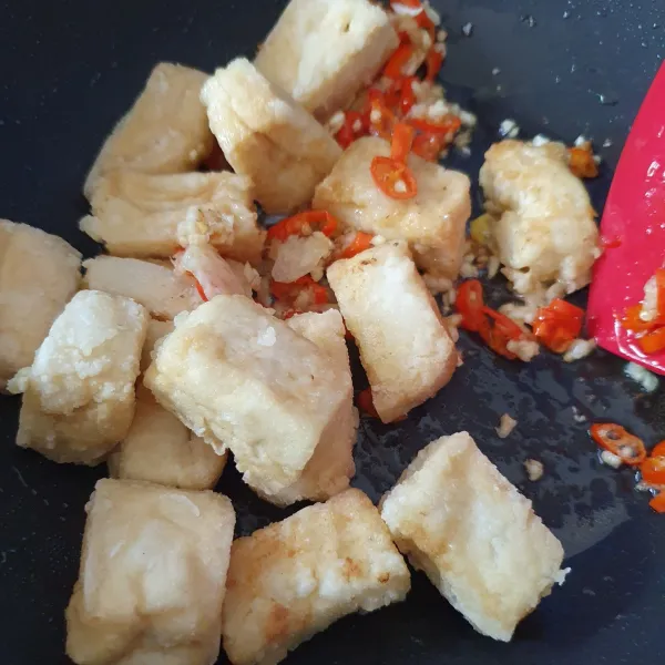 Masukkan tahu goreng, aduk. Tambahkan kaldu jamur dan garam.