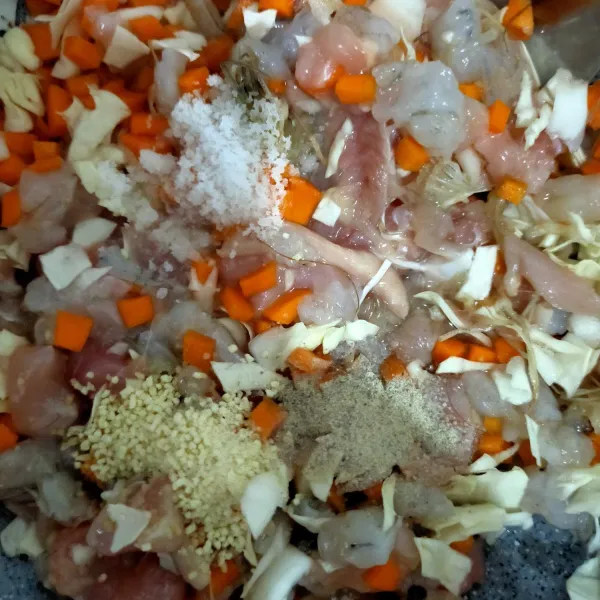 Masukkan, wortel, bawang putih halus, daun bawang, ayam dan udang  ke dalam wadah. Bumbui dengan garam, lada dan kaldu bubuk.