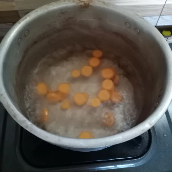 Didihkan air di panci. Masukan wortel. Masak sampai wortel setengah matang.