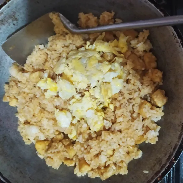 Setelah nasi sudah tercampur bumbu dengan baik, masukan telur, aduk rata.