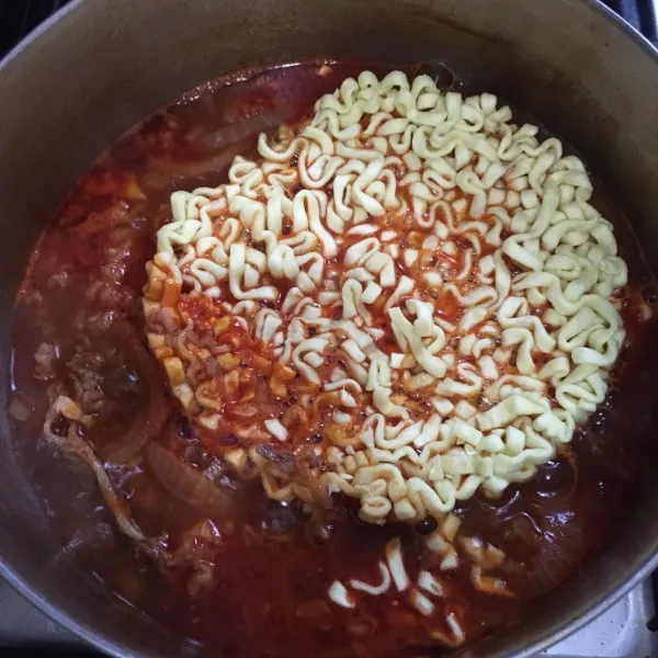 Masukkan ramen. Masak hingga mie ramen matang.