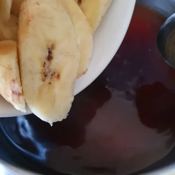 Masukkan gula merah sisir ke dalam panci rebusan, aduk. Lalu masukkan pisang iris.