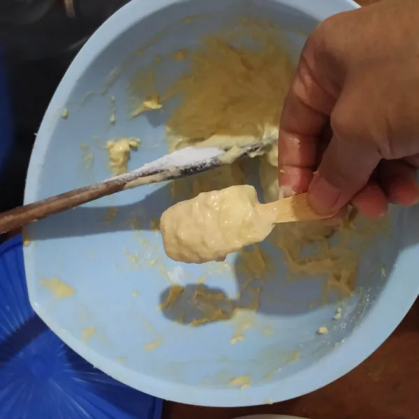 Setelah 60 menit, aduk adonan supaya udaranya keluar. Celupkan keju mozarella ke dalam adonan terigu sambil diputar-putar.