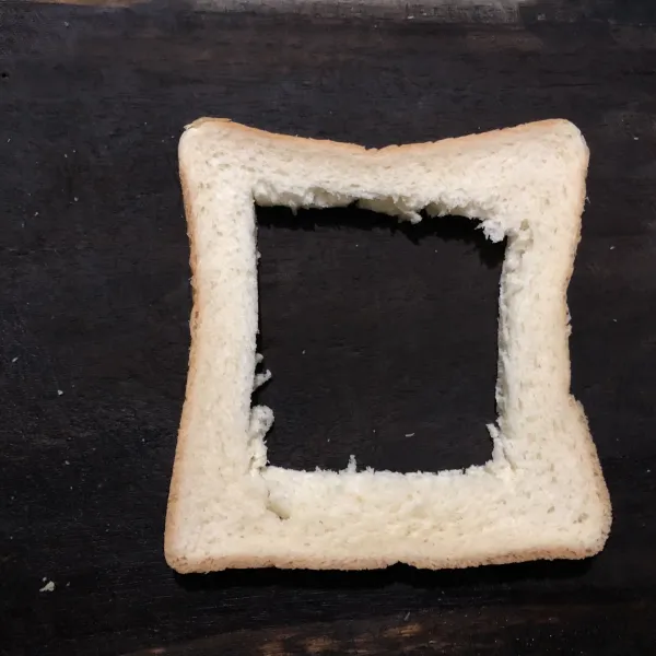 Potong tengah roti berbentuk kotak, olesi pinggiran kulit dengan mentega.