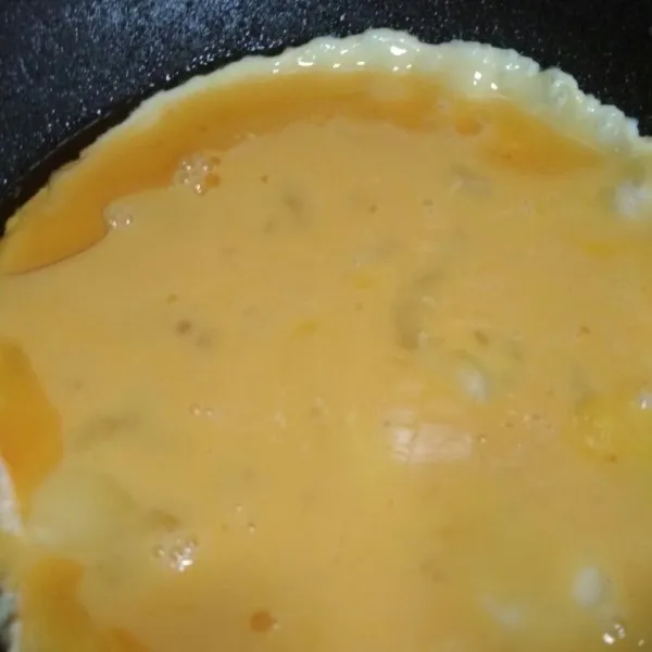 Kocok lepas telur campur dengan garam dan sejumput lada bubuk, tuang ke dalam teflon