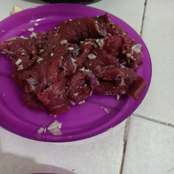 Slice daging sapi lalu lumuri dengan garam bawang putih cingcang dan lada hitam bubuk