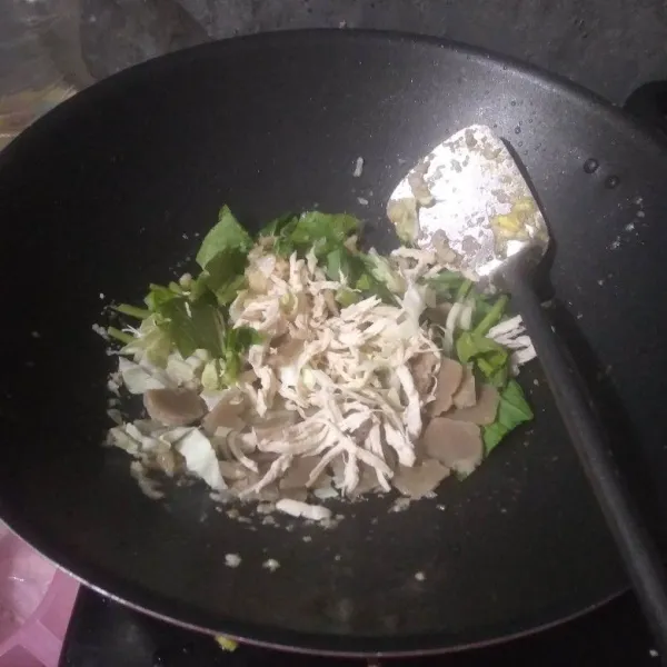 Masukan sawi, daun bawang, irisan baso dan ayam suwir. Aduk-aduk hingga sawi layu.