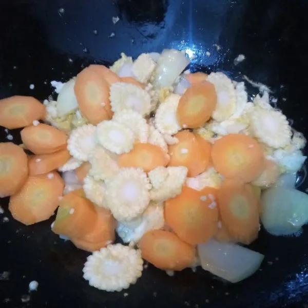 Masukan wortel dan jagung semi, aduk rata. Kemudian tambahkan ±500 ml air. Masak hingga wortel dan jagung semi setengah empuk