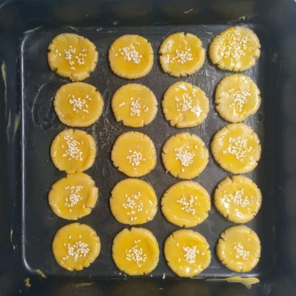 Ambil sedikit adonan, bulatkan. Lalu tata di loyang, olesi dengan kuning telur dan taburi dengan wijen. Oven hingga matang.