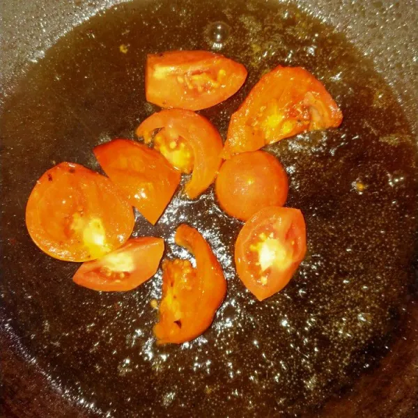 Panaskan minyak. Masukkan tomat hingga setengah matang.