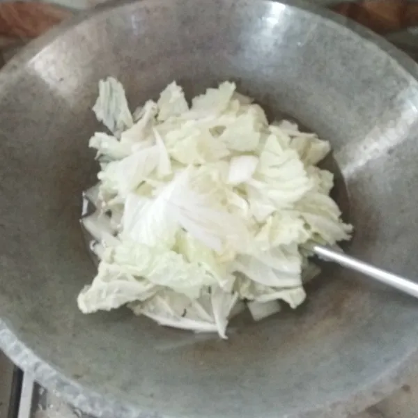 Masukan daun sawi putih. Tutup wajannya sebentar. Masak hingga daunnya aga layu.