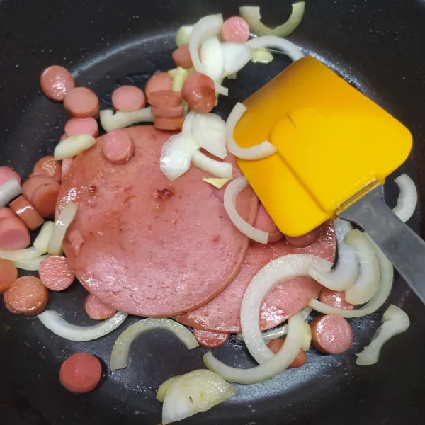 Panaskan margarin. Tumis irisan bawang bombay, sosis dan beef burger sampai harum dan sedikit layu.