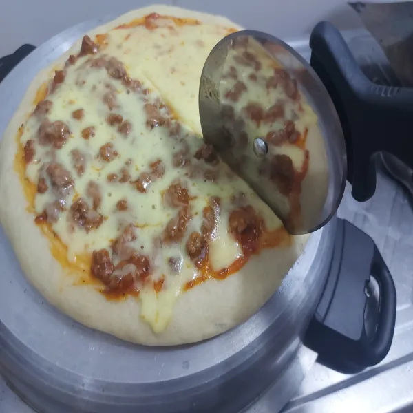 Potong pizza , susun di tempat saji.