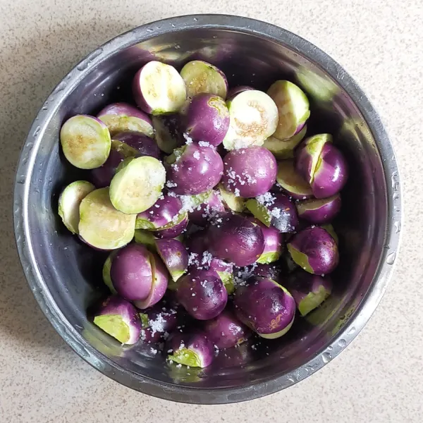 Belah terong, menjadi dua bagian, lalu cuci bersih dan beri sedikit garam aduk rata.