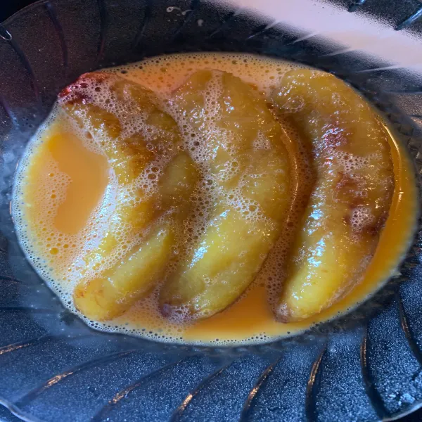 Kocok telur dan masukan pisang yang telah digoreng. Balur hingga seluruh permukaan merata.