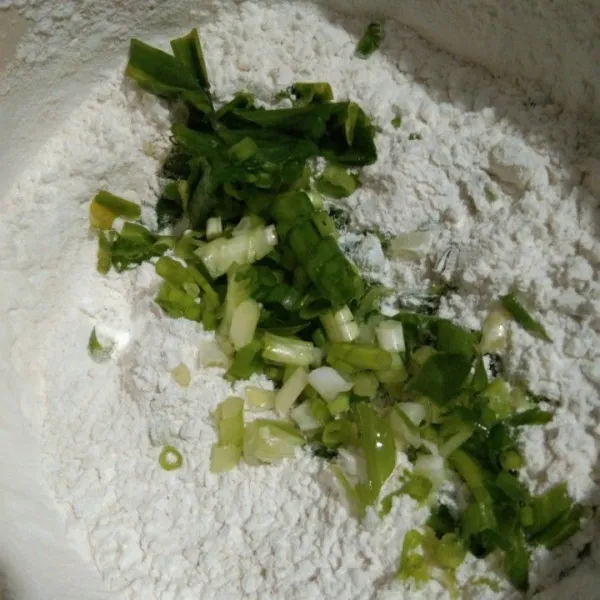 Campurkan irisan bawang daun dengan tepung tapioka, tepung terigu, garam, merica bubuk dan kaldu jamur, aduk rata