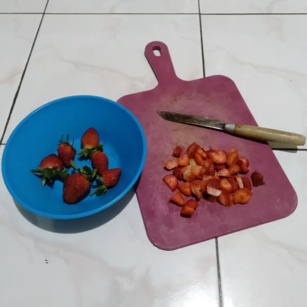 Sambil menunggu bolu matang, siapkan sausnya, cuci bersih strawberry dan potong kecil-kecil