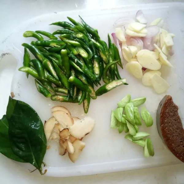Cuci bersih dan iris cabe hijau, bawang merah, bawang putih, petai, laos dan gula merah.