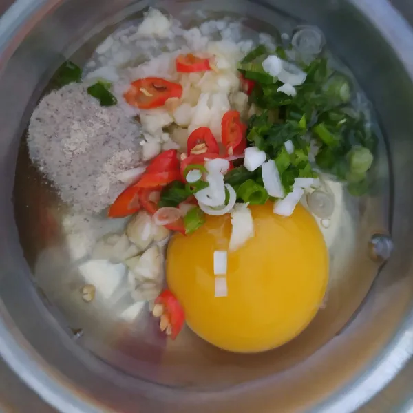 Dalam mangkok, pecahkan telur. Masukkan garam, merica, bawang putih, cabe dan daun bawang. Kocok lepas.