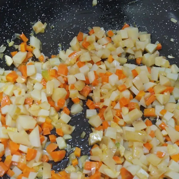 Masukan kentang dan wortel, sambil terus diaduk.