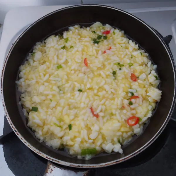 Masukkan nasi ke dalam kocokan telur, aduk rata. Kemudian goreng menggunakan teflon.