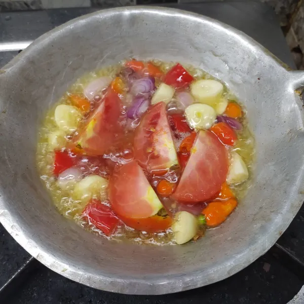 Goreng bawang merah, bawang putih, cabe merah, cabe rawit dan tomat sampai matang.