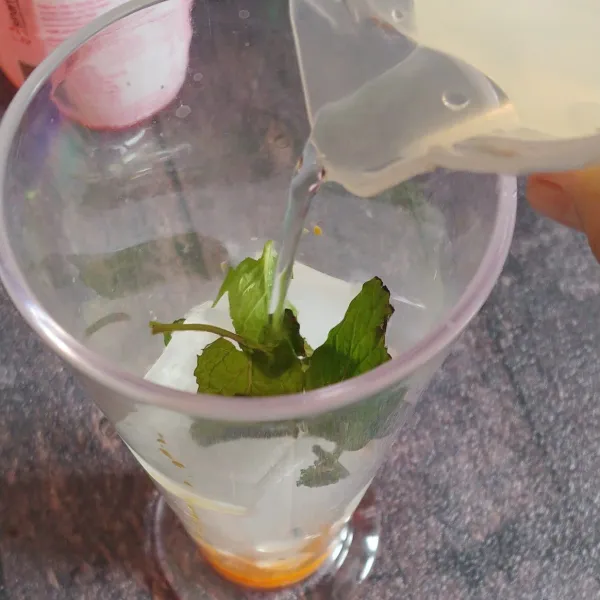 Masukkan daun mint dan gula pasir yang sudah dicairkan dengan air panas dan sudah dingin saat dicampur kedalam gelas.