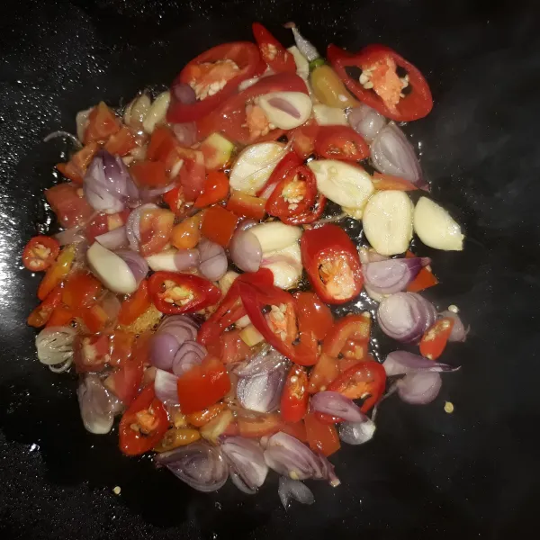 Panaskan minyak, tumis bawang merah, bawang putih, cabe rawit, cabe merah besar dan tomat hingga harum.