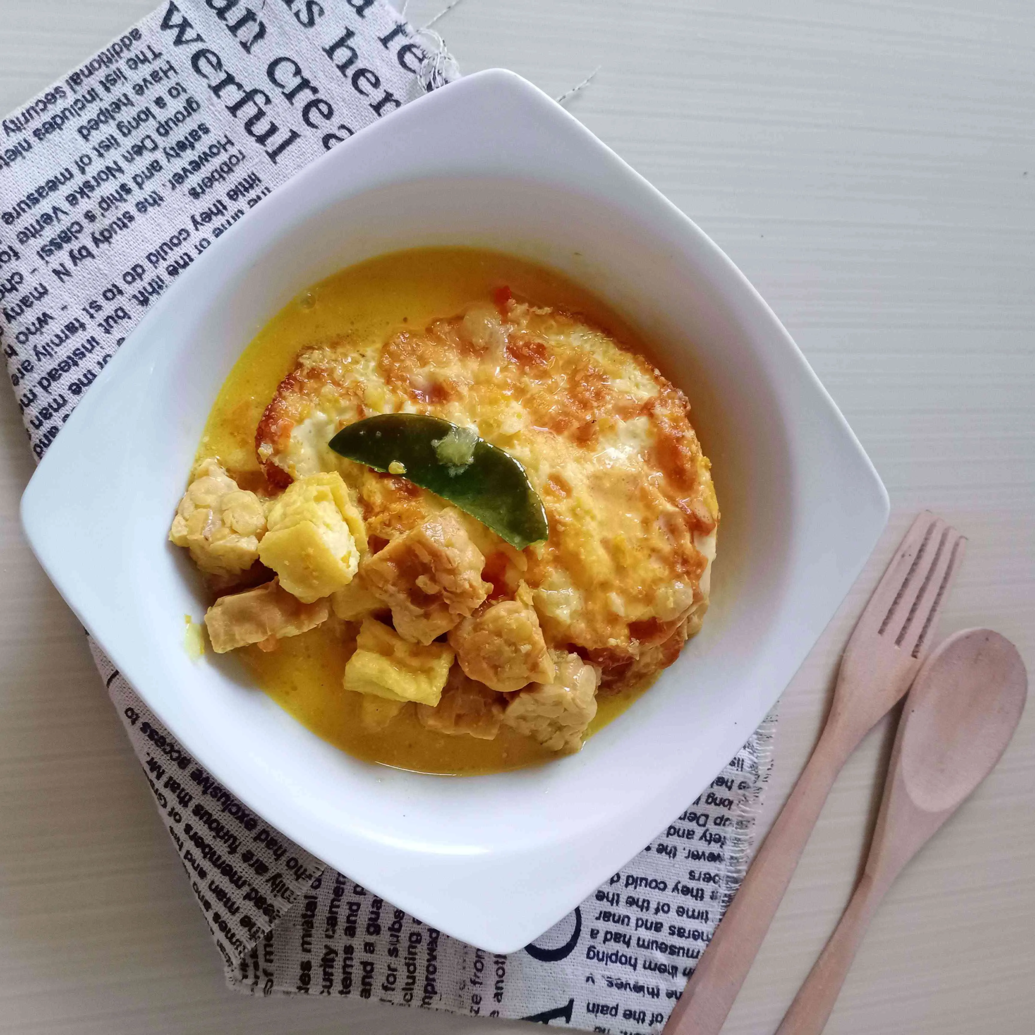 Piring tahu tempe santan dengan beras merah di sampingnya