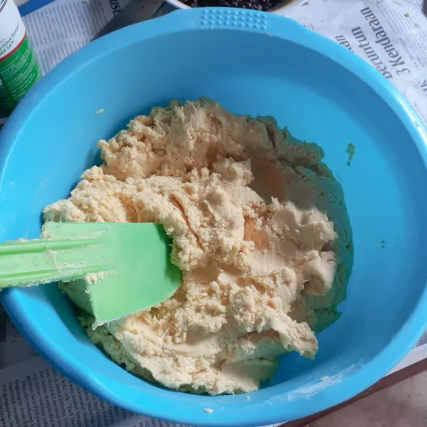 Masukkan susu bubuk dan terigu. Aduk rata dengan spatula.