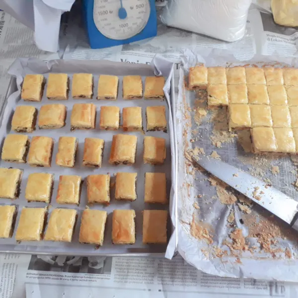 Keluarkan dari loyang lalu potong-potong. Tata kembali di loyang. Oven dengan api sedang cenderung kecil di rak tengah selama 15 menit.