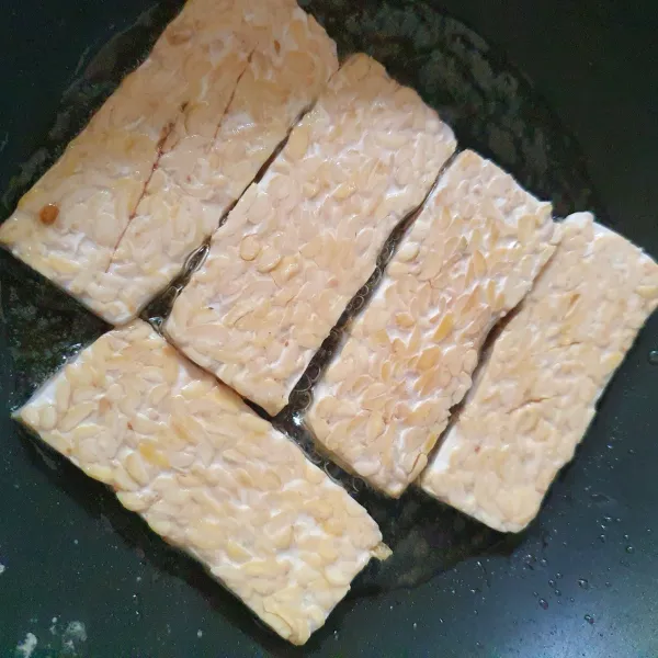 Haluskan bawang putih dan garam, beri air. Rendam potongan tempe, lalu goreng.