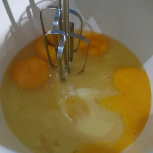 Siapkan wadah. Masukan gula pasir dan telur serta emulsifier. Mixer kurang lebih 8 menit atau sampai adonan putih kental berjejak. Setelah selesai matikan mixer.