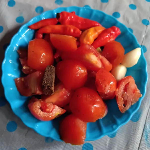 Siapkan bahan, potong-potong tomat, dan lukai cabe agar tidak meletus ketika digoreng.