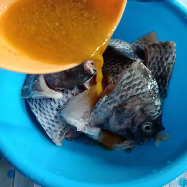 Siramkan bumbu pada ikan nila, aduk rata dna diamkan 15 menit.