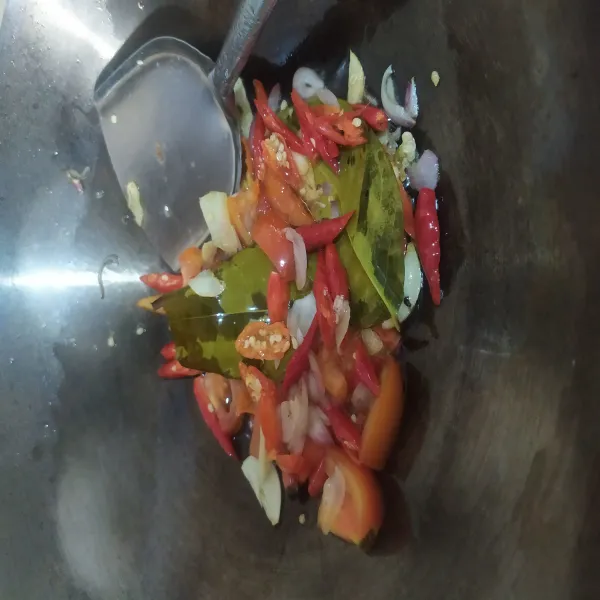 Panaskan minyak, tumis irisan bawang putih, bawang merah dan daun salam sampai harum, lalu masukan irisan cabai dan tomat, aduk rata