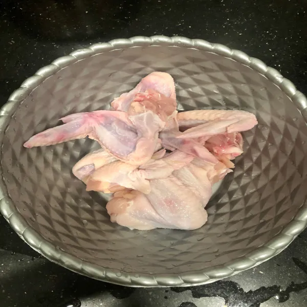 Cuci bersih sayap ayam lalu tusuk-tusuk dengan garpu agar bumbunya meresap.