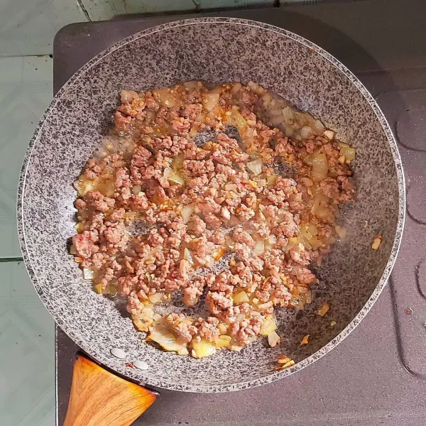 Panaskan minyak, masukkan bawang putih cincang, tumis sampai harum. Masukkan daging cincang kemudian bumbui dengan garam, gula, penyedap rasa dan lada sesuai selera. Angkat dan sisihkan terlebih dahulu.