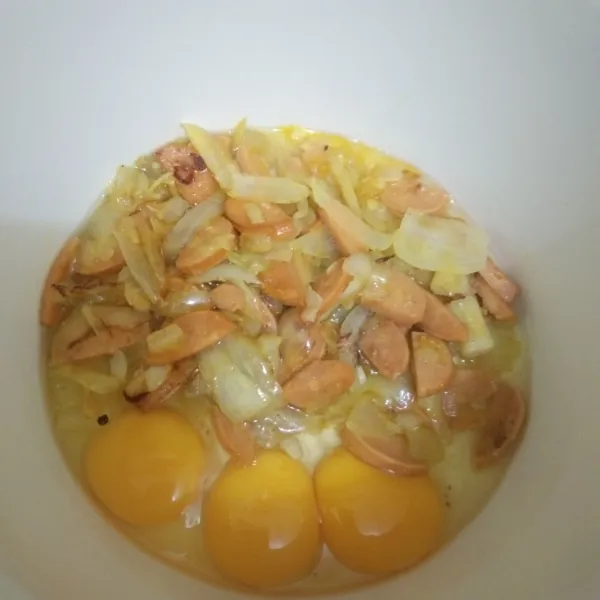 Dalam wadah campur telur dan tumisan bawang sosis, aduk rata