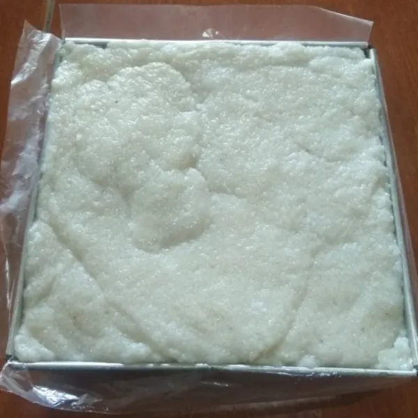 Siapkan loyang 20x20 cm. Olesi permukaannya dengan plastik (saya pakai plastik tilam pipiti). Alasi seluruh bagian loyang dengan plastik (agar mudah saat ngeluarin ulennya). Lalu masukan adonan ulen kedalam loyang sambil ditekan-tekan agar padat.