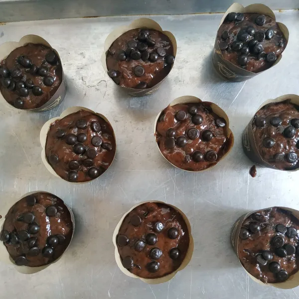 Siapkan cup muffin, tuang adonan sebanyak 3/4 dari tinggi cup kemudian taburi dengan chocochip diatasnya, masukkan ke dalam oven dan panggang sampai matang.