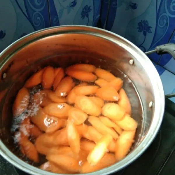Didihkan air, rebus irisan wortel hingga setengah matang