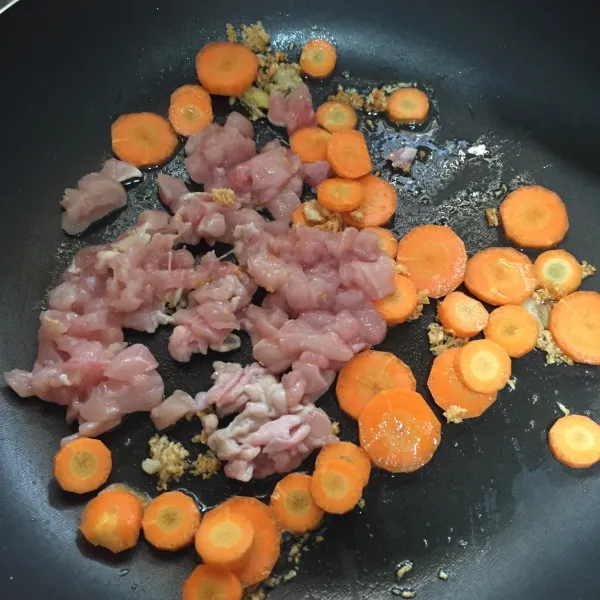 Masukkan ayam dan wortel, masak hingga ayam berubah warna.